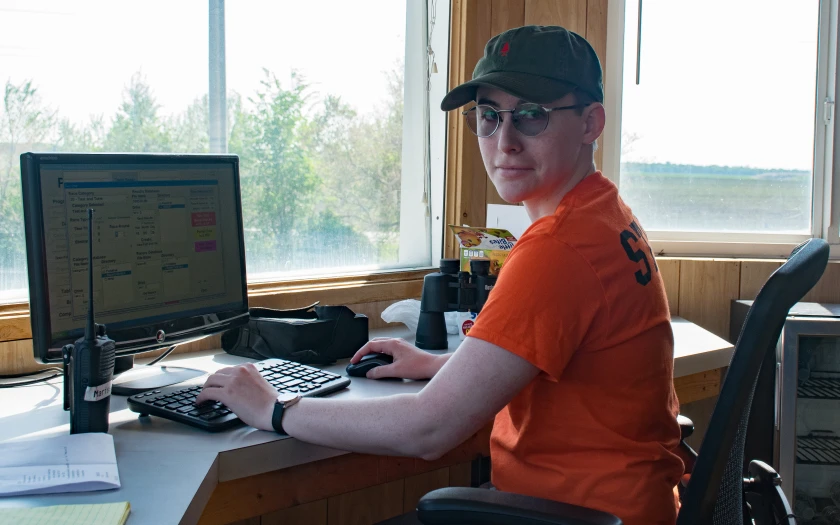 Marissa in an orange shirt in front of the timing computer at Interstate Raceway